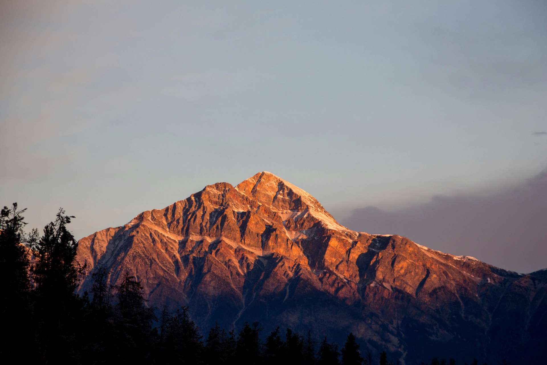 Sun rising behind a mountain peak